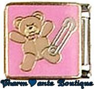 Ourson en peluche et épingle sur fond rose